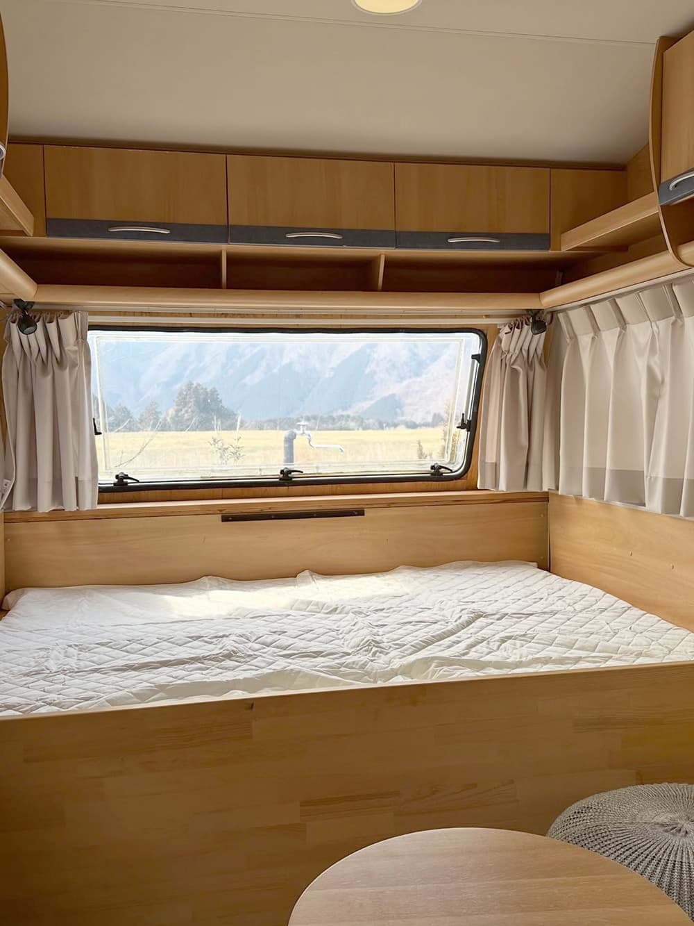 A bed in a trailer house at Urban Camping Asagiri Takarayama in Fujinomiya City, a campsite with a view of Mt. Fuji